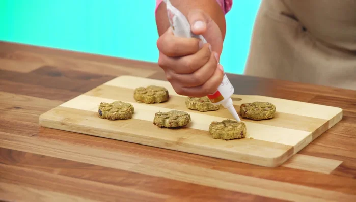 Frost the cooled biscuits with the remaining peanut butter and decorate as desired.