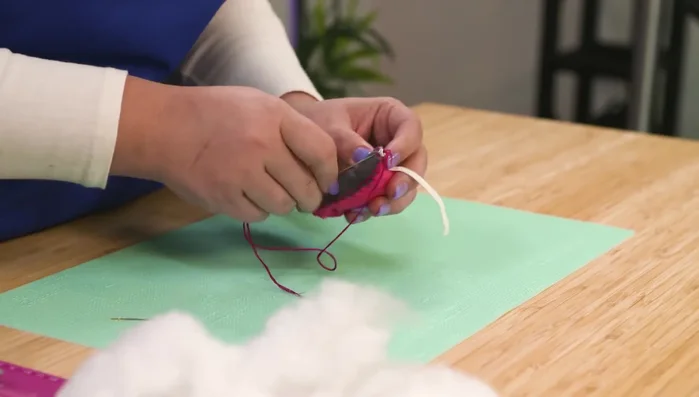 Sew the elastic tail to the back of the mouse.