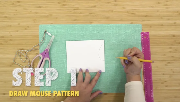 Create the mouse pattern: Fold paper, draw half a teardrop and half a heart, measure half the circumference for side piece length, then cut out patterns.