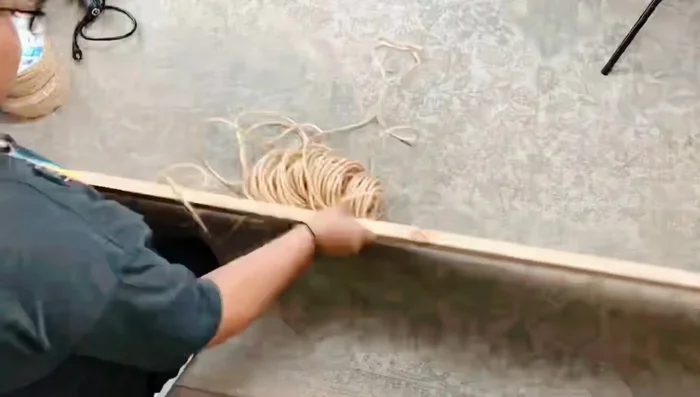 Wrap jute rope around the wooden board to create the cat scratching post.