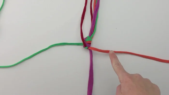Repeat step 3, alternating the over/under pattern in each row to create a square knot. Continue until you have enough length for the loop (approximately 8.5 inches, as shown in the video).