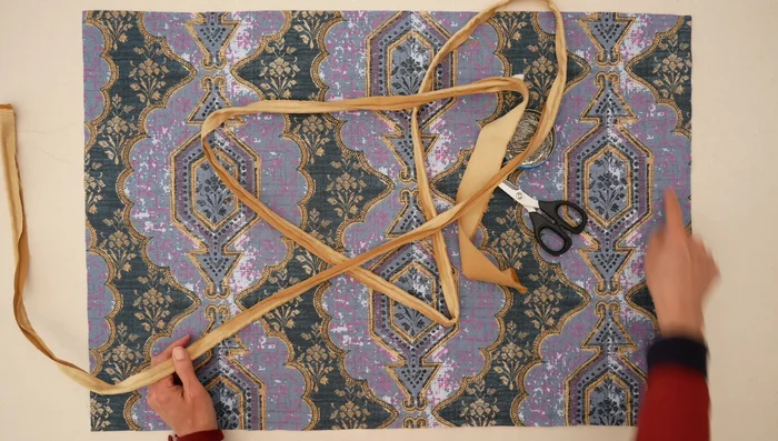 Attach piping to top piece: Sew piping to the right side of the top piece, starting in a corner. Clip seam allowance at corners to allow for turning.