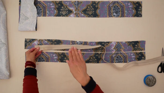 Attach zipper to back pieces: Place zipper face down on top back piece, aligning long edges. Sew zipper tape to the top back piece, then to the bottom back piece. Press fabric next to zipper teeth, then sew close to zipper teeth on both sides to reinforce.