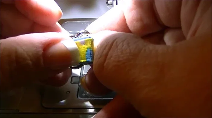 Insert the collar material through the tri-glide slide and sew it down with a zig-zag stitch, reinforcing the seam.