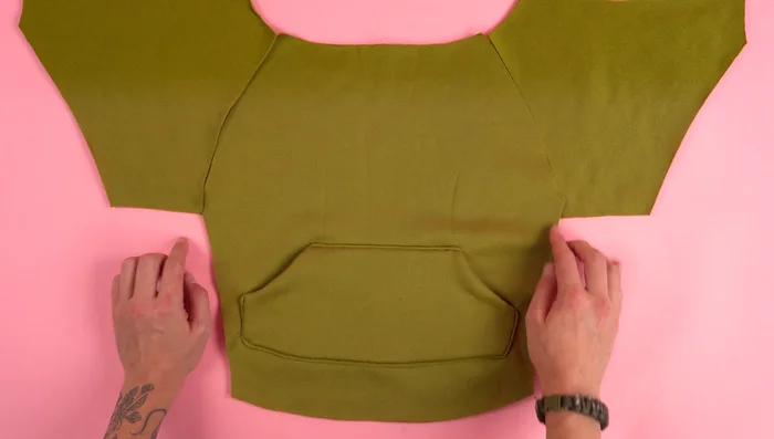 Attach Sleeves: Attach the sleeve panels to the back panel, ensuring a smooth, even seam. Add top stitching.