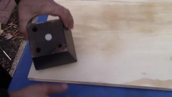 Attach the four feet (from the old sofa) to the four corners of the plywood platform using 2.5-inch screws.