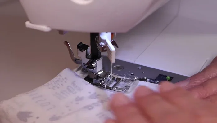 Sew the sleeves: Cut out two sleeve pieces, sew the long edge of each, turn right side out, and pin them to the armholes. Sew securely, ensuring alignment.