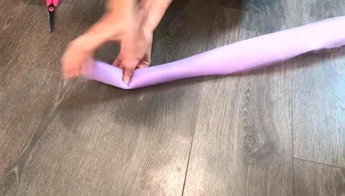 Prepare tulle strips. Fold over the folded end to remove excess fabric. Cut approximately 4 inches to achieve desired width.