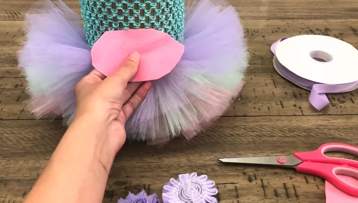 Attach flowers to the dress. Glue the felt backing to the inside of the tutu, then glue the shabby flowers onto the felt, positioning the central flower at the midpoint of the dress’s back.