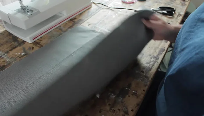 Stitch the long edge of the side piece to the base fabric, folding over the edge for a clean finish.