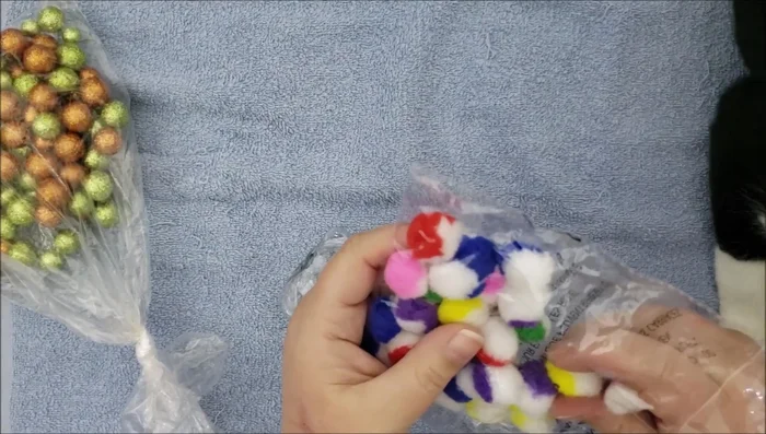 Add decorative items: Add various items like pom-poms, feathers, and small pieces of ribbon for visual stimulation and texture. Consider using festive colors for Christmas.