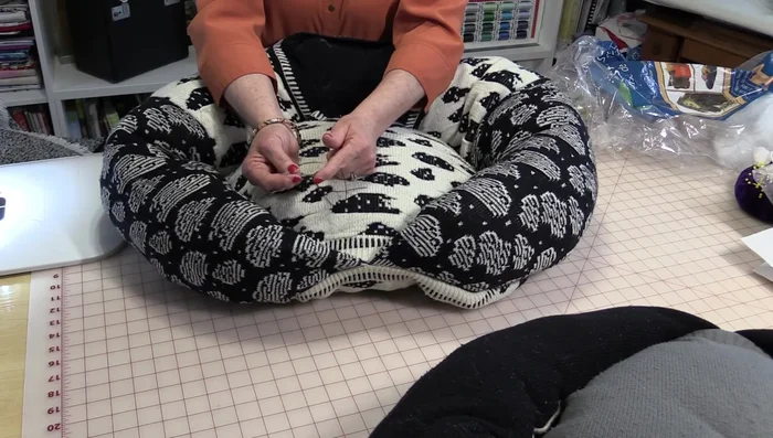 Create a dimple in the center of the pillow by using a needle with at least four strands of thread to create a strong seam. Push the needle through the top and then back out a half-inch away. Pull tightly to create the dimple and tie off.