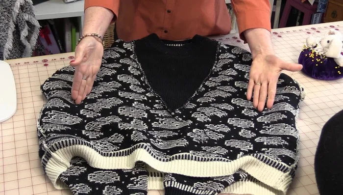 Pull both ends of the sweater together to meet in the middle, creating a gap in the corner. Match up the bottom and sleeve seams.