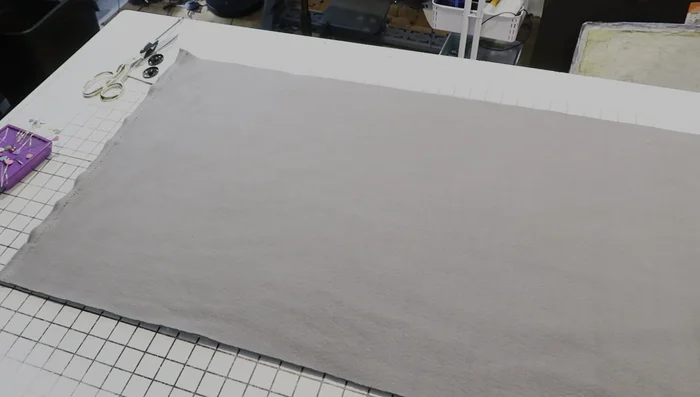 Cut and prepare the fabric pocket. Cut a piece of fleece slightly larger than your desired pocket size (add seam allowance). Fold and press the edges inward (½ inch on sides and bottom, 1 inch on top).