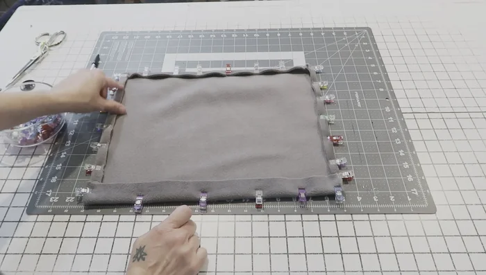 Sew the fabric pocket edges. Stitch down the folded edges to secure them in place. Use a straight stitch for simplicity.