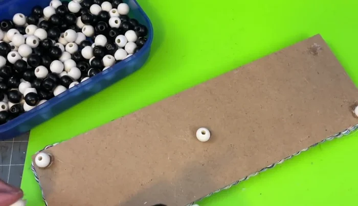 Glue white wooden beads to the bottom of the tray.