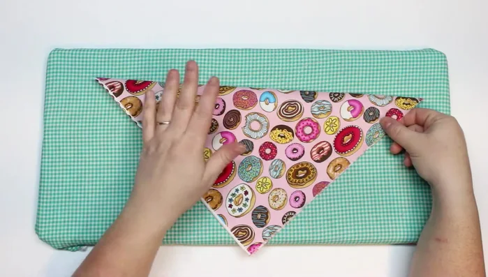 Fold the square in half diagonally and score to create a guideline. Open it back up.