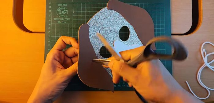 Create holes on both sides of mask and attach strips for wearing.