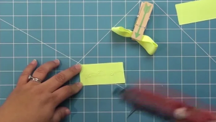 Apply hot glue to the center of the folded ribbon and press to create a narrower center piece.