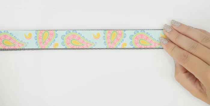 Attach handle. At the other end, slip on a D-ring (optional, skip if not making treat bag). Fold over 7 1/2 inches, ensuring raw edges align with the swivel hook. Fold under a quarter inch and stitch across multiple times. Stitch the D-ring securely into its own pocket.