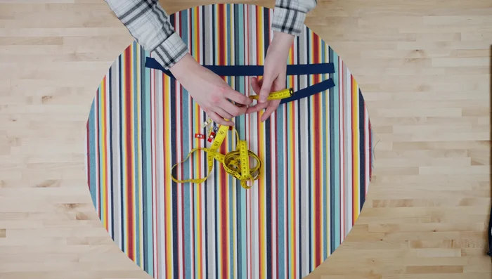 Cut two 18-inch webbing strips; pin handles 4 inches apart on either side of the circle.