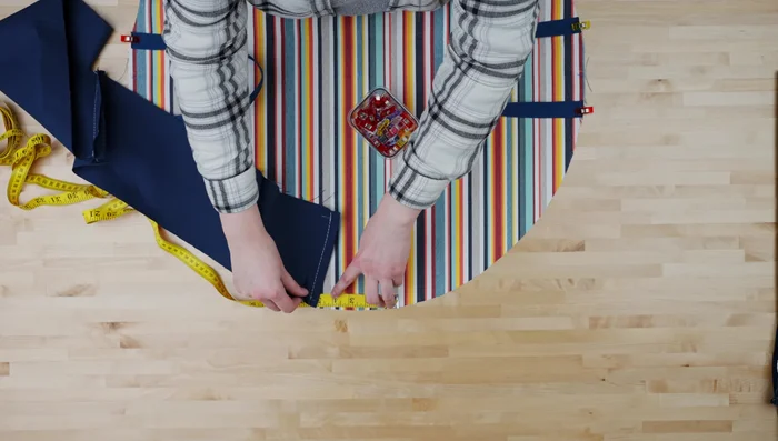 Cut 15 feet of rope in half; loop around edges, fold fabric strip over rope, and pin.