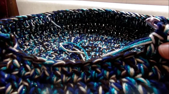 Create the opening: Chain three, turn, and single crochet around the perimeter of the opening, working back and forth rows. Leave 12 stitches open. Chain 12 across the gap, slip stitch to join. Then work additional rounds of single crochet around the opening until the desired size is achieved.