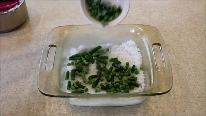 Layer the remaining 1.5 cups of cooked rice on top of the vegetables.