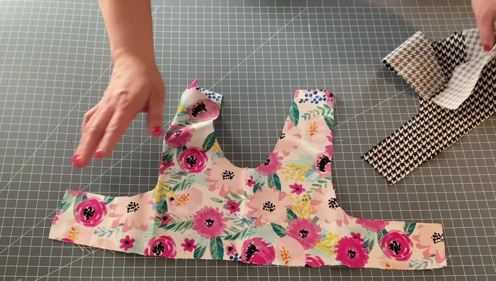 Attach the D-ring. Position the decorative fabric strip, gather and attach it to the top center of the front bodice piece, incorporating the D-ring.