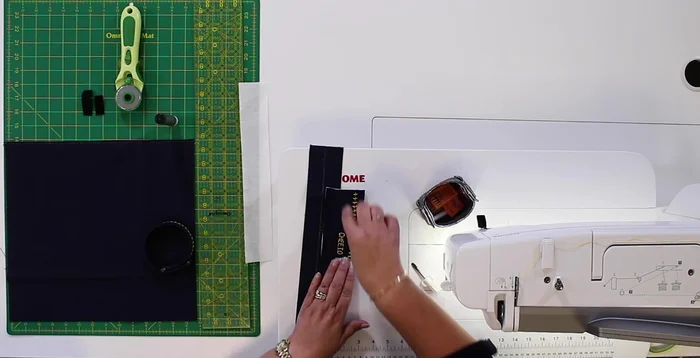 Fold fabric in half, finger press to find center. Mark name placement based on sample.