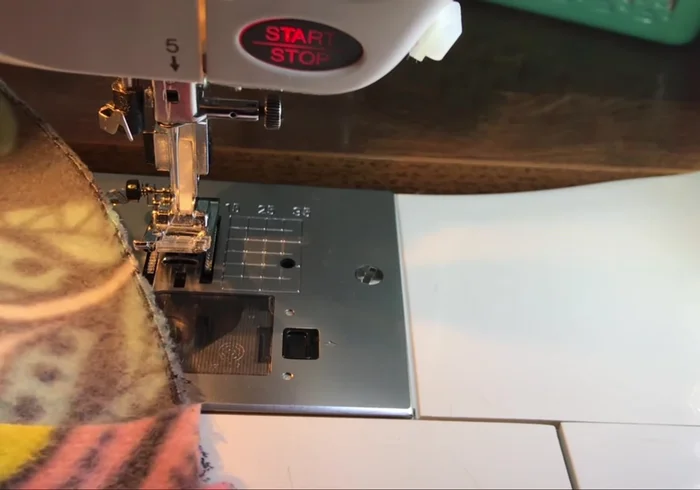 Fold the bolster wrong sides together, flattening the seam. Clip around the edges and stitch closed using an elastic zigzag stitch, leaving the previously zigzagged opening unstitched.