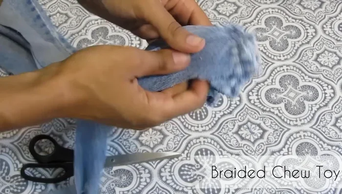 Remove the rubber band. Tie two strands at one end, wrap them around the core, and tie a knot. Repeat at the other end.