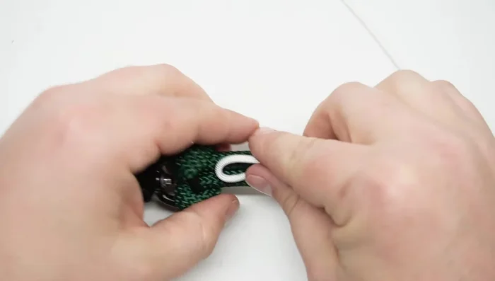 Whip the rope to the clip using paracord. Create a loop on one end and wrap the paracord around the rope, securing it with a locking method. Pull tight and cut/seal the excess paracord.