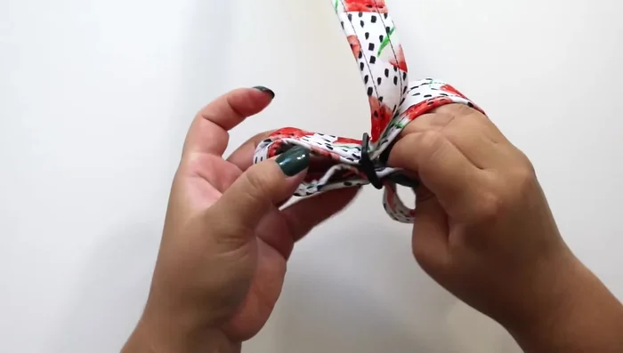 Double the strap under and over the first strap, then sew the end to the inside of the loop, securing it in place with a strong stitch (e.g., a rectangle with an X).