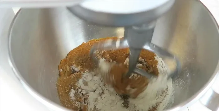 Gradually add 2 1/2 cups of flour, 1/2 cup at a time, mixing until a stiff dough forms. If using a stand mixer, switch to the dough hook; otherwise, mix by hand.