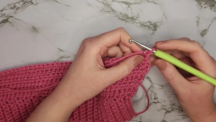 Row 8: Six half double crochets, chain ten, skip ten stitches, half double crochet into the next stitch, 25 more half double crochets, chain ten, skip ten stitches, six half double crochets.