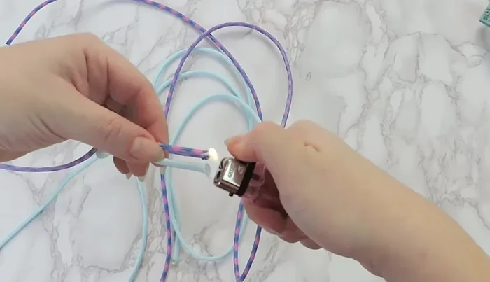 Join the ends of the different colored paracord and melt them together to create a single point.