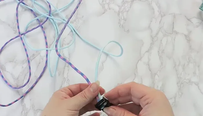 Tape the buckle to a surface, ensuring equal distance between male and female parts to match the desired collar size.