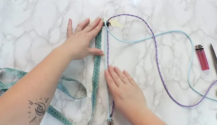 Tape the buckle to a surface, ensuring equal distance between male and female parts to match the desired collar size.