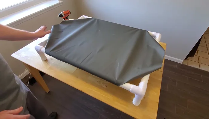 Secure all sides: Continue adding screws along all four sides, tightening the fabric and ensuring evenness. Add extra screws for added strength.