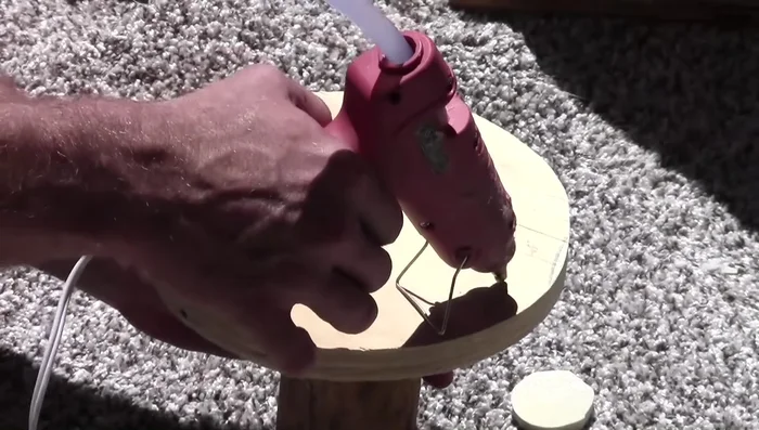 Glue the carpet padding circles onto the platform supports to create mushroom shapes.