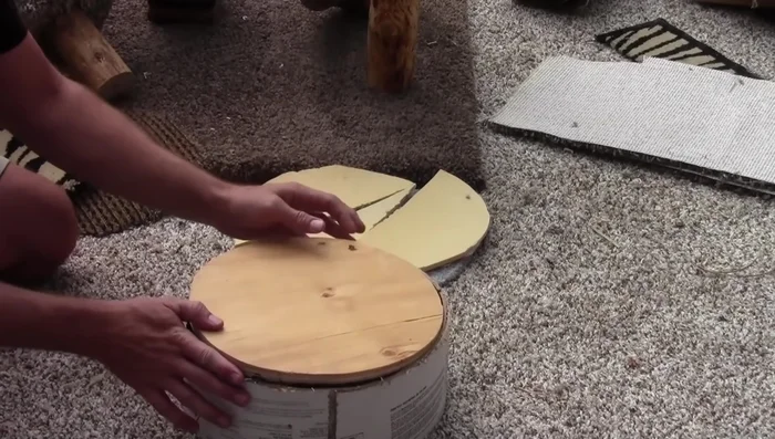 Attach carpet padding and carpet to the bottom of the round bed using staples and glue.