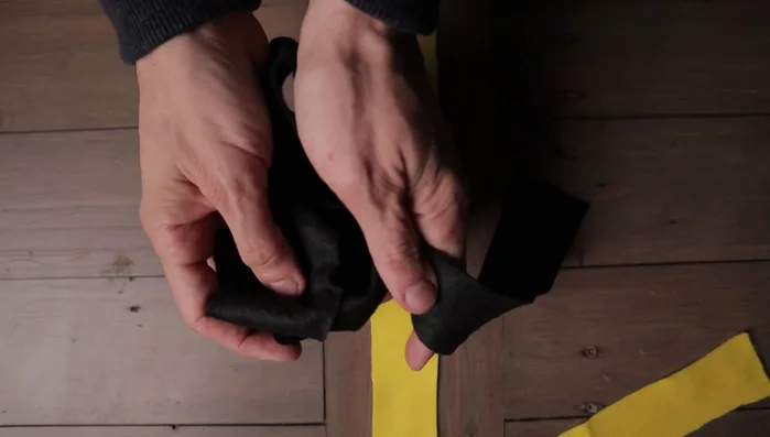 Place the second fleece strip (black in example) across the center of the first strip, creating a cross.