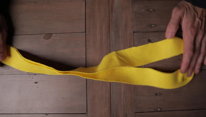 Place the second fleece strip (black in example) across the center of the first strip, creating a cross.