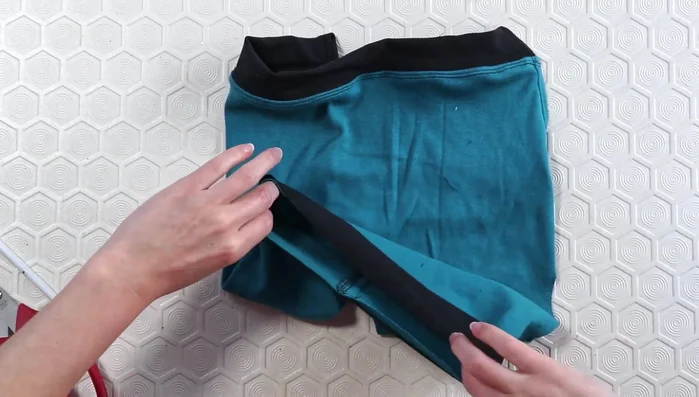 Serge neck binding edges and pin to neckline. Stitch with a single needle (then serge edges again for a cleaner finish, then topstitch with the double needle)