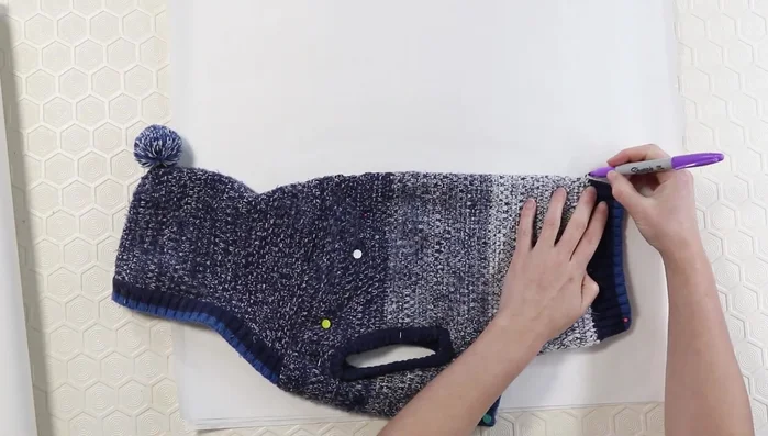 Use pins to transfer seam markings from the sweater to the paper.
