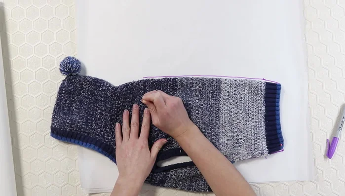 Use pins to transfer seam markings from the sweater to the paper.