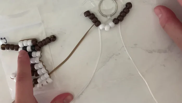 Continue adding rows: Follow the specified bead patterns for each row (refer to the video for the exact sequence). For each row, string the beads onto one string and then thread the second string through the beads in the opposite direction, creating a secure and stable structure.