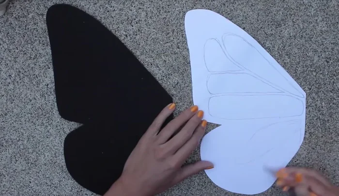 Cut small circle pieces from felt and glue them onto the wing to create a pattern; repeat with white felt.