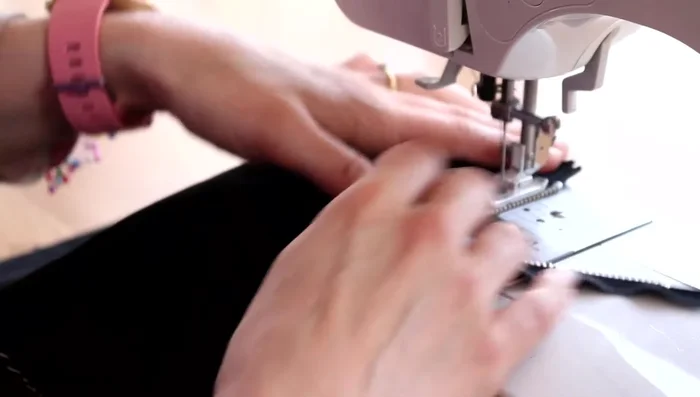 Sew down the fold, close to the zip.